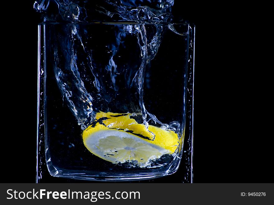 Citron flows into glass of water. Citron flows into glass of water