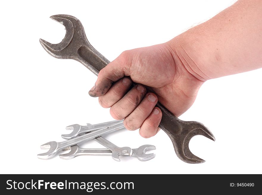 A metallic wrench is in a hand