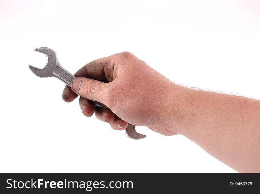 A metallic wrench is in a hand