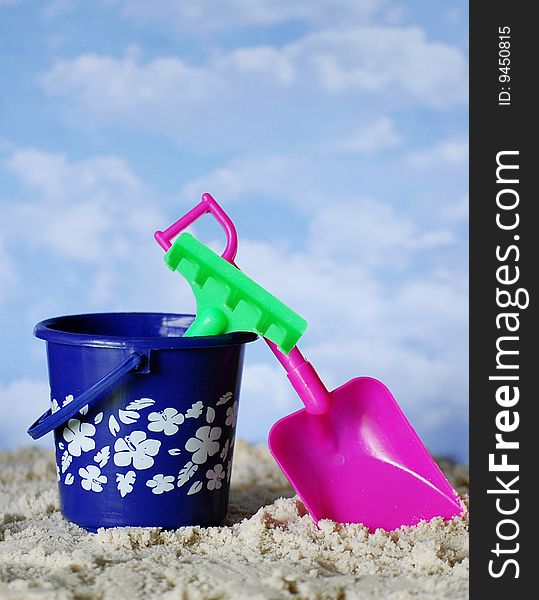Colorful plastic beach toys in the sand