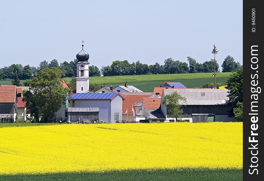 A little village behind a rape field using solar energy. A little village behind a rape field using solar energy