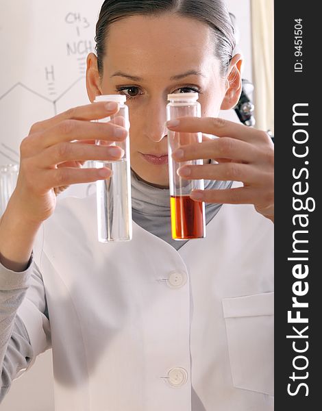 Chemist holding two flasks containing chemicals. Chemist holding two flasks containing chemicals