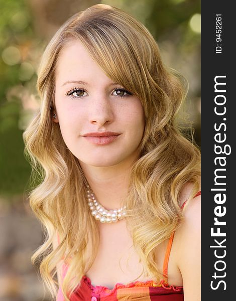 Close-up of pretty teenager looking relaxed sitting outside