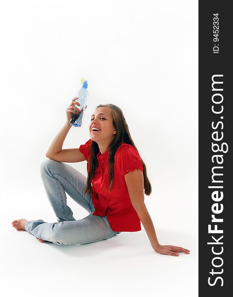 The woman sitting on a floor with a water bottle on a white background. The woman sitting on a floor with a water bottle on a white background