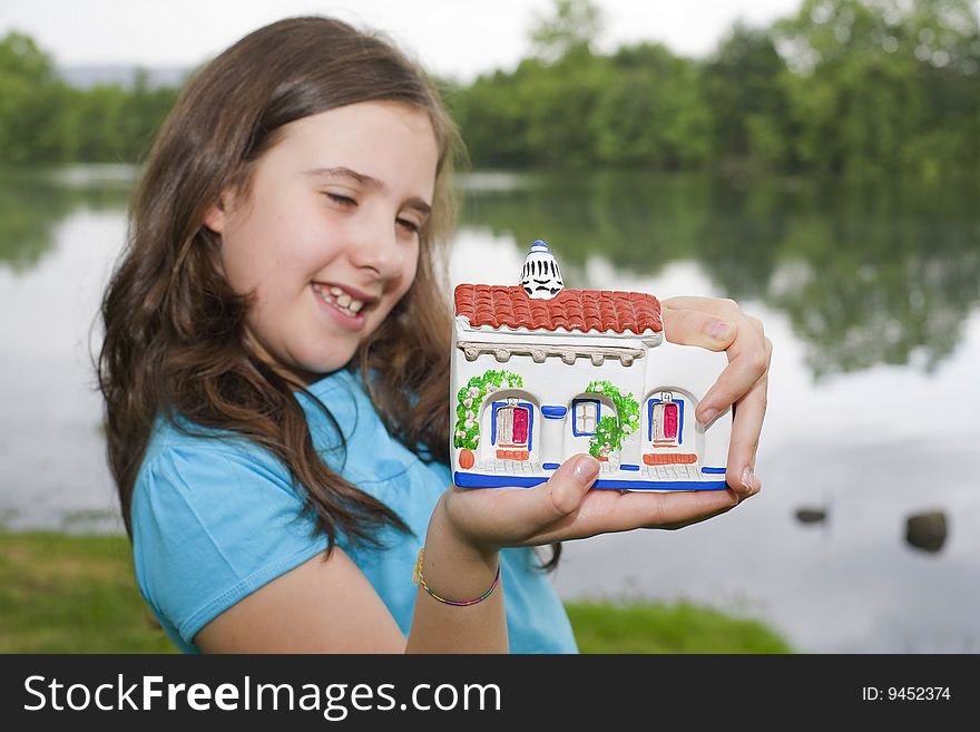 A young girl holding a little house on her hands. A young girl holding a little house on her hands