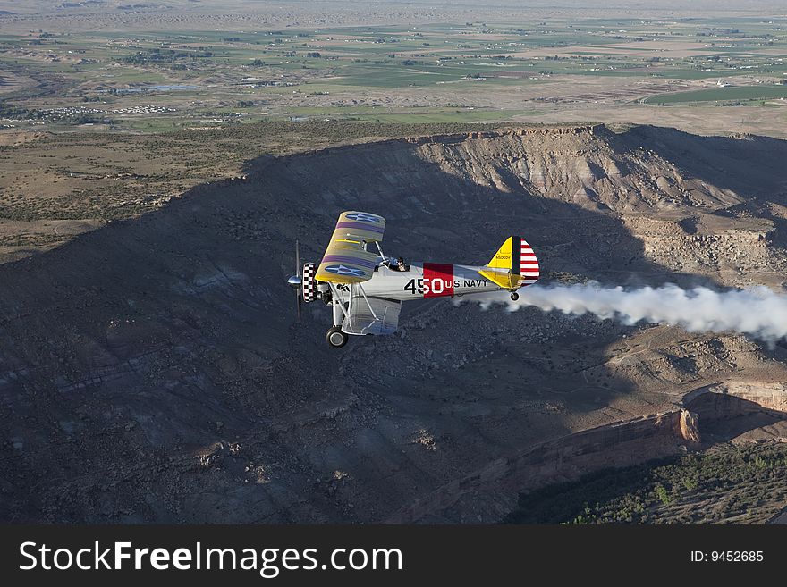 Yellow biplane over desert