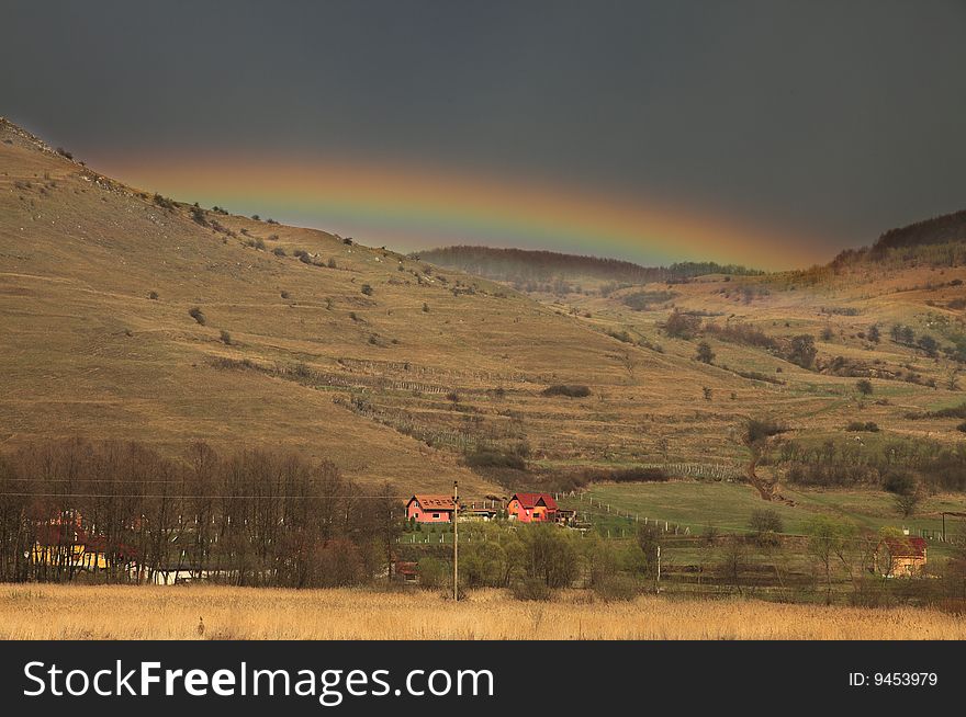 Beautiful rainbow just after the storm in a mountainous rural area.