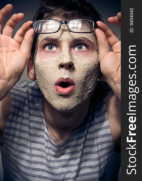 Close-up portrait of funny man with facial mask and glasses