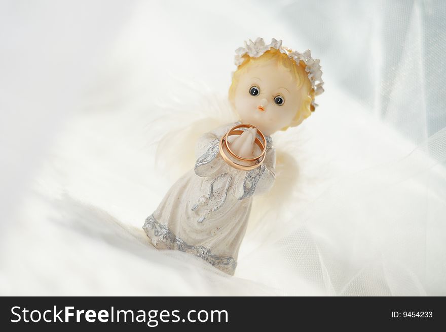 The colour image of a little angel with the gold wedding rings