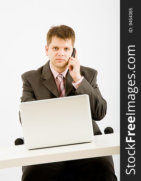 Young businessman working with phone and laptop computer