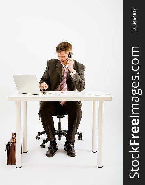 Young businessman working with phone and laptop computer