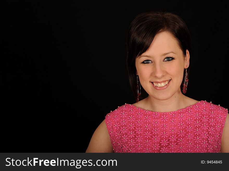 Horizontal closeup portrait of a smiling young woman, isolated against a black background. Horizontal closeup portrait of a smiling young woman, isolated against a black background.