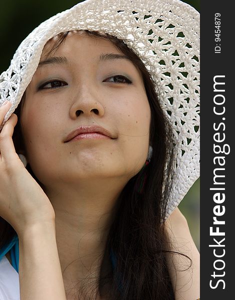 Portrait of a young Asian woman with a summer hat