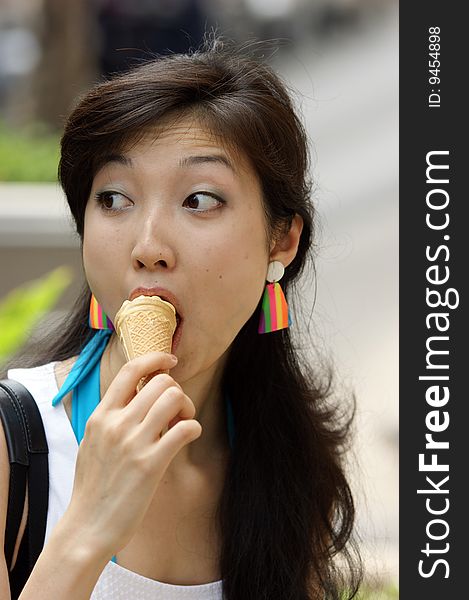 A Portrait of a young Asian woman eating ice cream