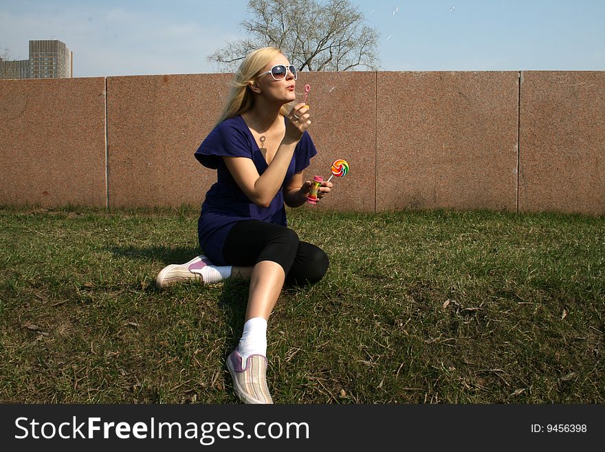 Girl blowing soap bubbles in a park