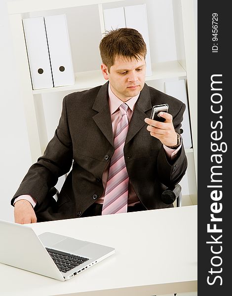 Young businessman working with phone and laptop computer