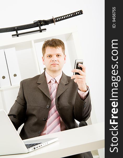 Young businessman working with phone and laptop computer