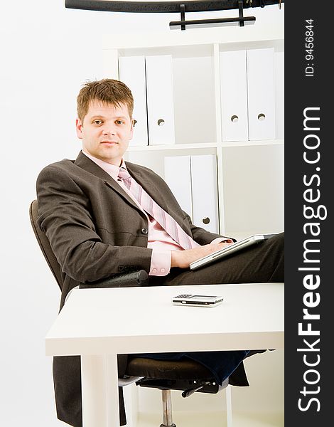 Young businessman working with phone and laptop computer