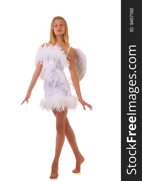 Young beautiful girl in a white dress with wings behind the back on a white background. Young beautiful girl in a white dress with wings behind the back on a white background