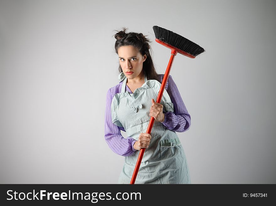 Portrait of a beautiful housewife with broom