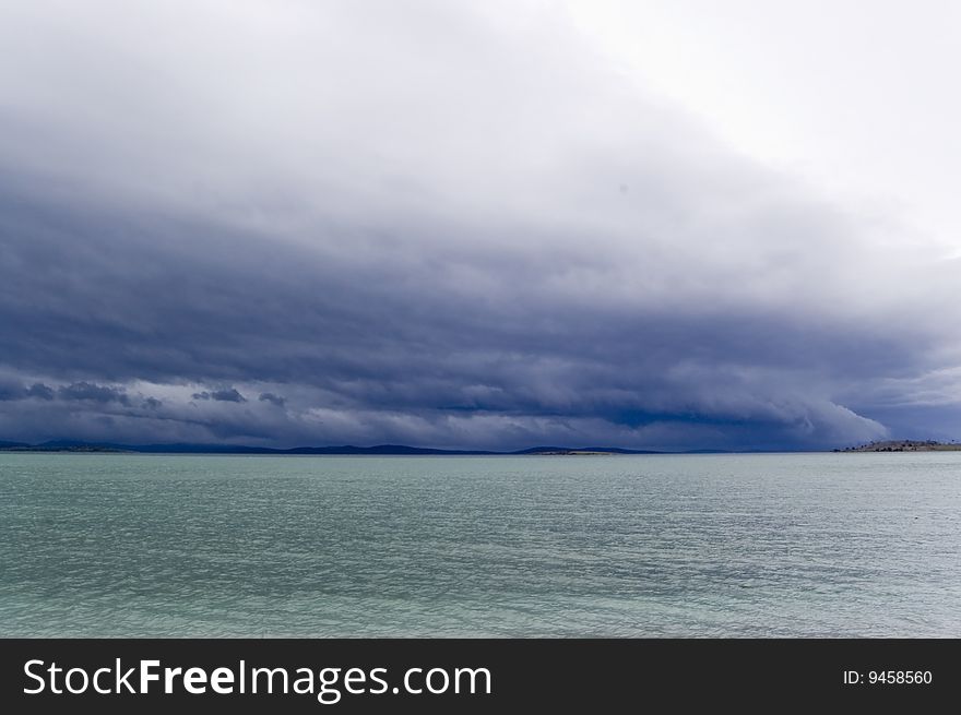 Dark blue storming sky and aquamarine water. Dark blue storming sky and aquamarine water