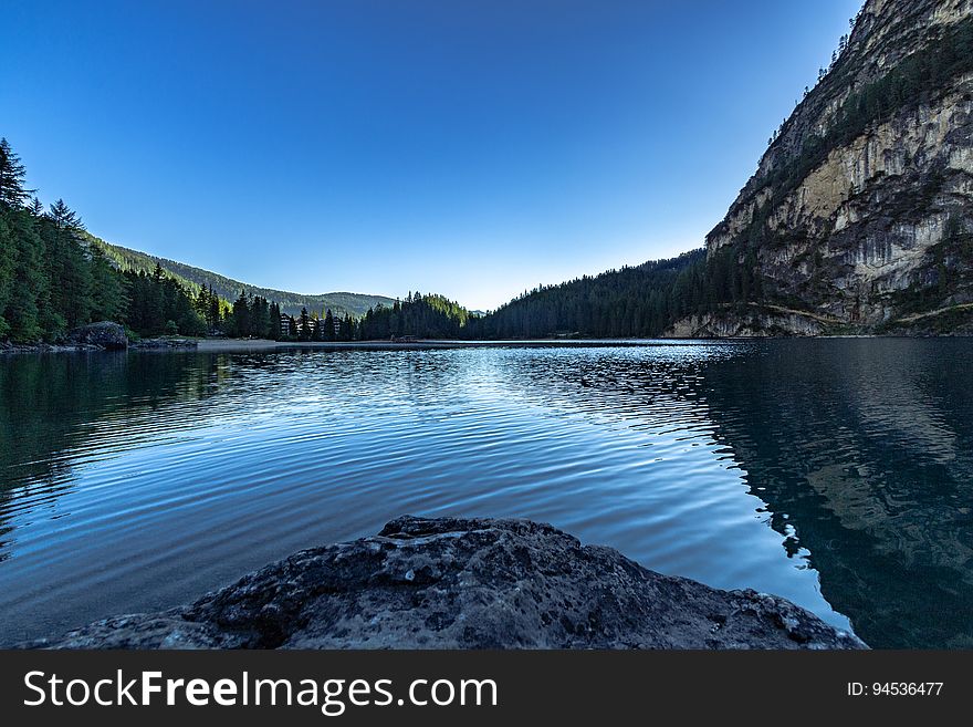 A mountain lake with blue skies reflecting on the surface.