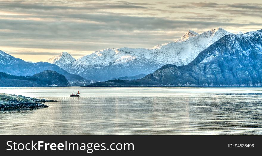 A person boating through fjords on a wintry day.