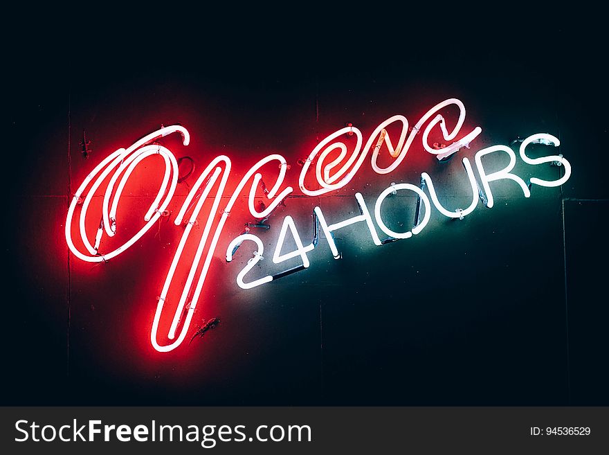 A neon sign with the text "Open 24 hours".