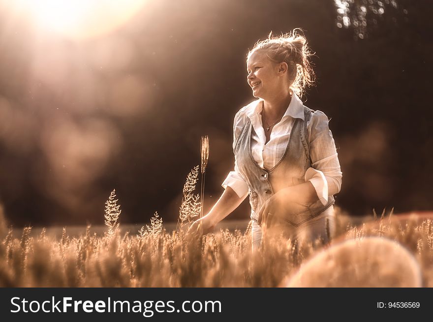 Mid Adult Woman in Wheat at Sunset