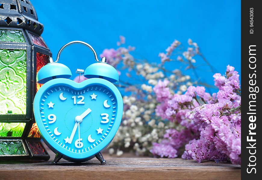 vintage alarm clock on wooden background with flowers decoration. vintage alarm clock on wooden background with flowers decoration