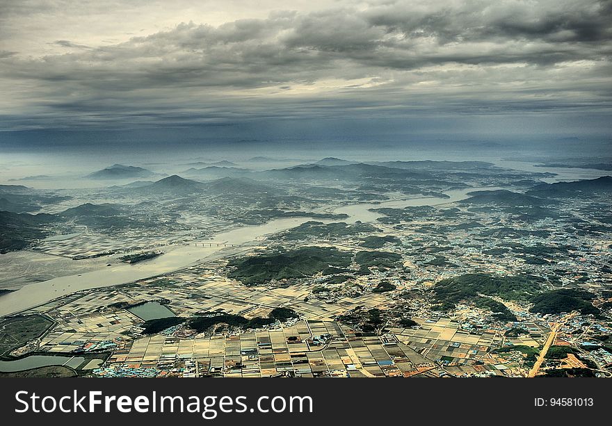 Aerial View Photo of Urban Area and Mountain Range in the Distance Under Gray Cloudy Sky