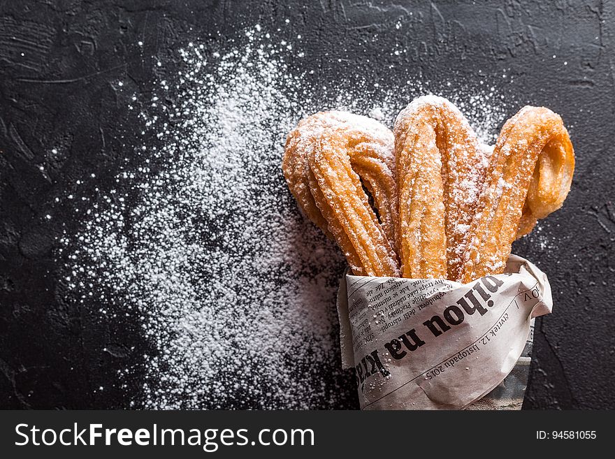 Closeup of churros dusted with powdered sugar.
