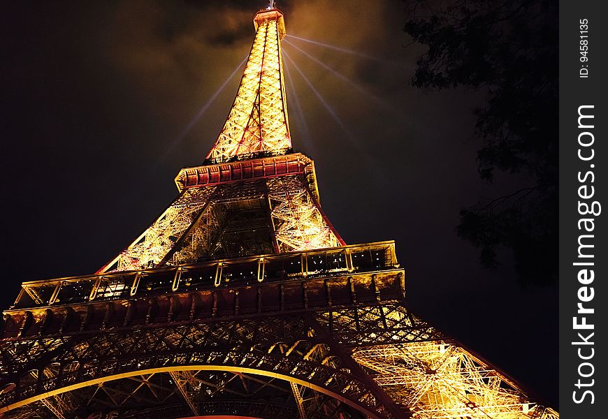 The Eiffel tower with the lights on at night. The Eiffel tower with the lights on at night.
