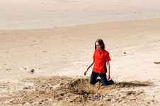 Girl Digging Hole In Sand At The Beach Stock Photography
