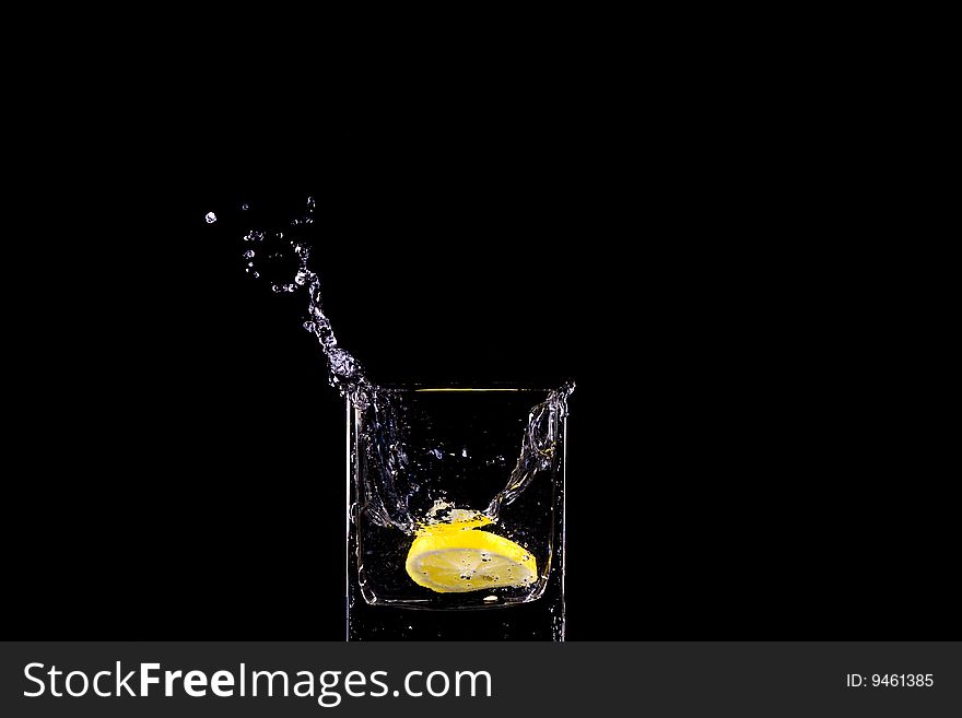 Citron flows into glass of water. Citron flows into glass of water