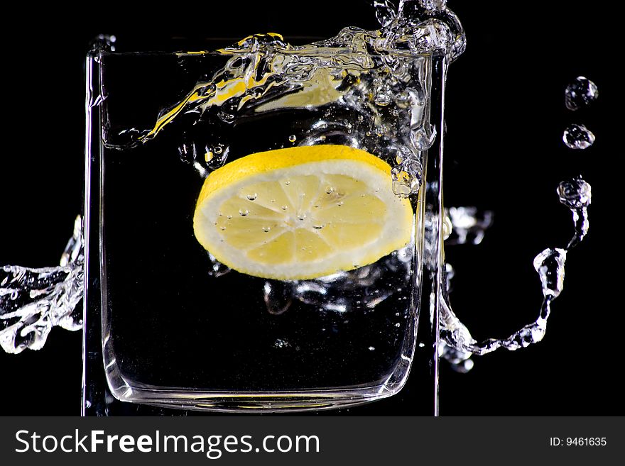 Citron flows into glass of water. Citron flows into glass of water