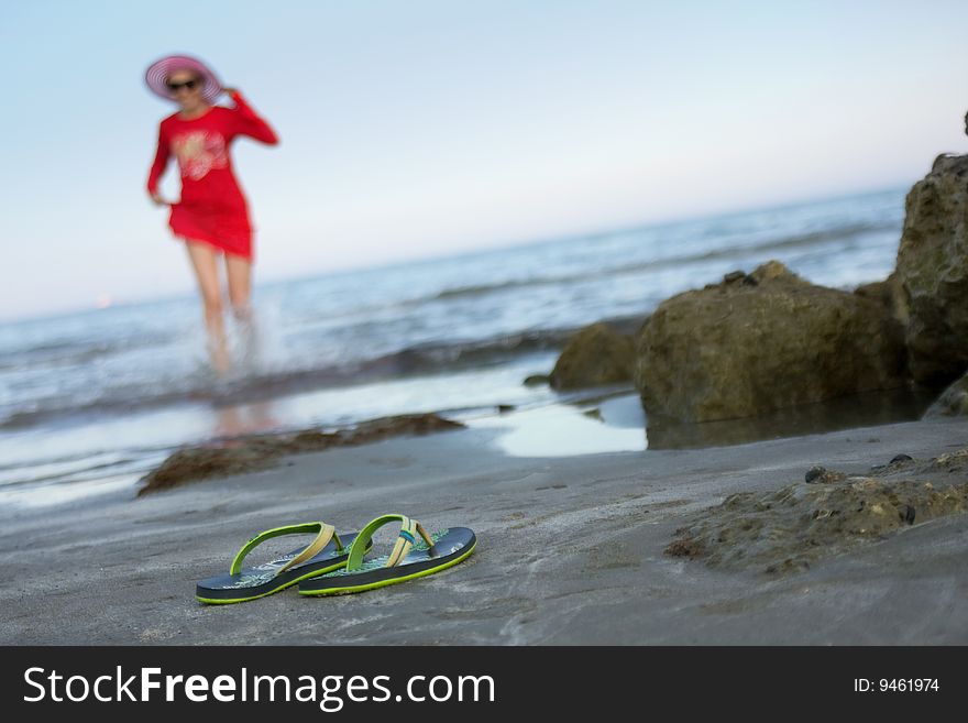 Young happy girl runs on coast of the blue sea