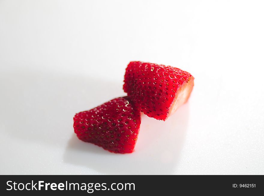 Sliced strawberries on a white matte. Sliced strawberries on a white matte.