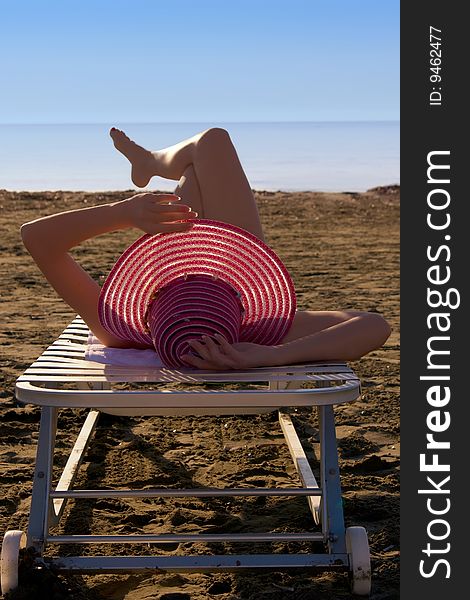 Young girl with a red hat is on sea coast