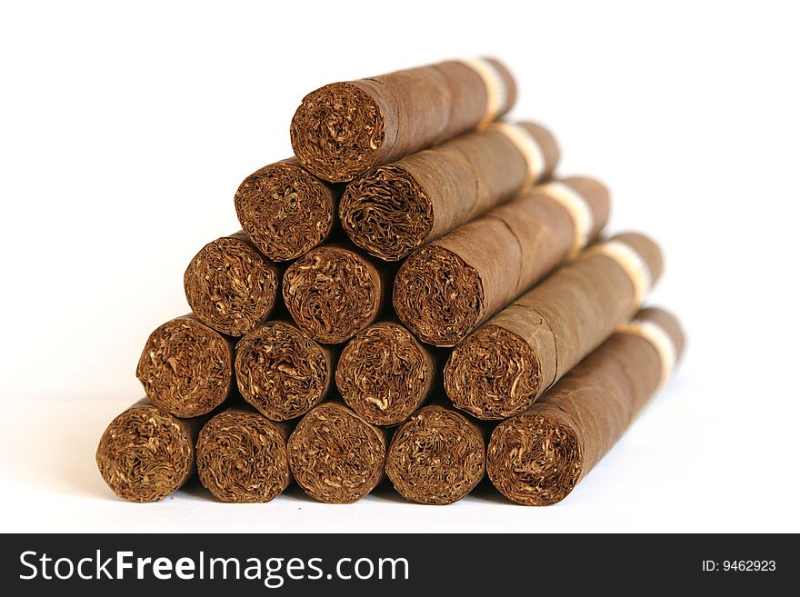 Cigars arranged as a triangle stack on a white background - side view picture.