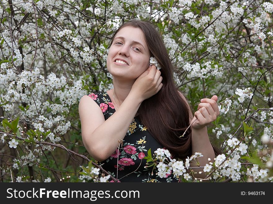 Portrait of young woman in the blossoming garden