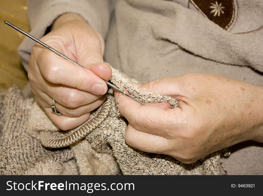 Old lady knitting the pullover.