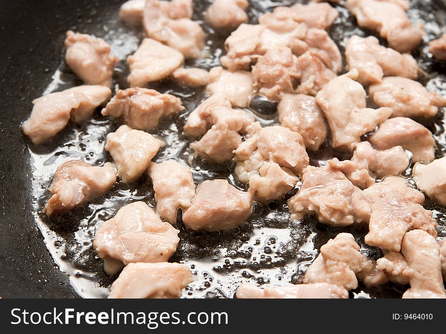 Cooking chicken meat in a pan