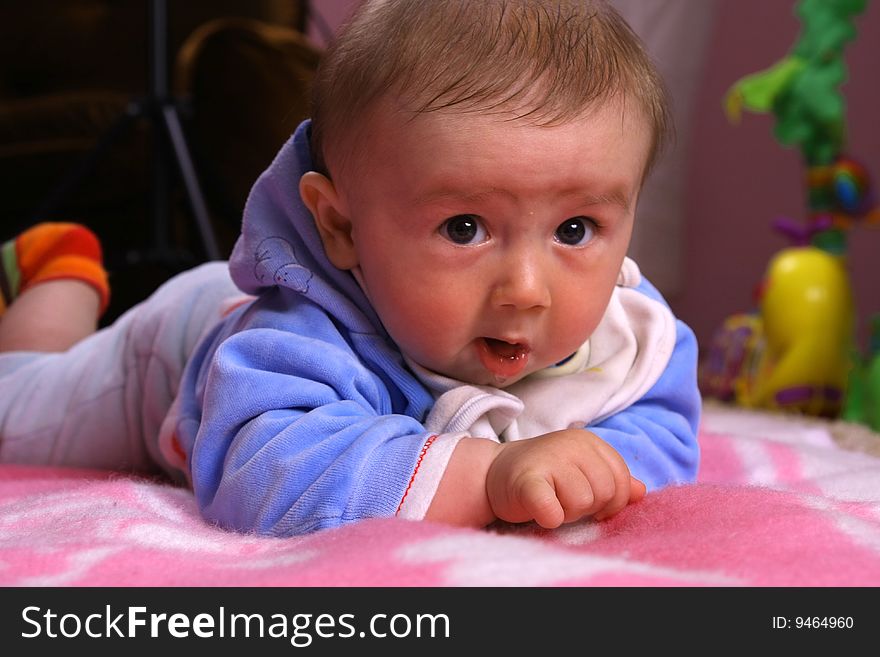 Small young child is playing on the blanket. Small young child is playing on the blanket