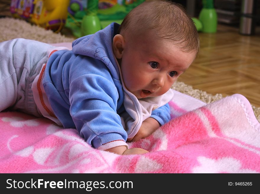 Small young child is playing on the blanket. Small young child is playing on the blanket