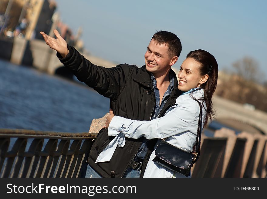 Young couple is laughing on embankment