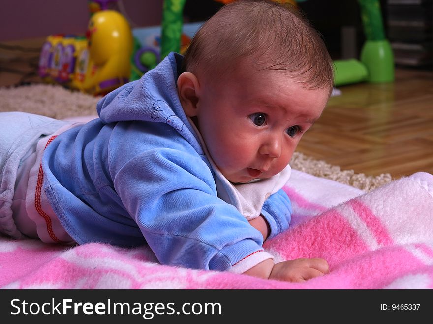 Small young child is playing on the blanket. Small young child is playing on the blanket