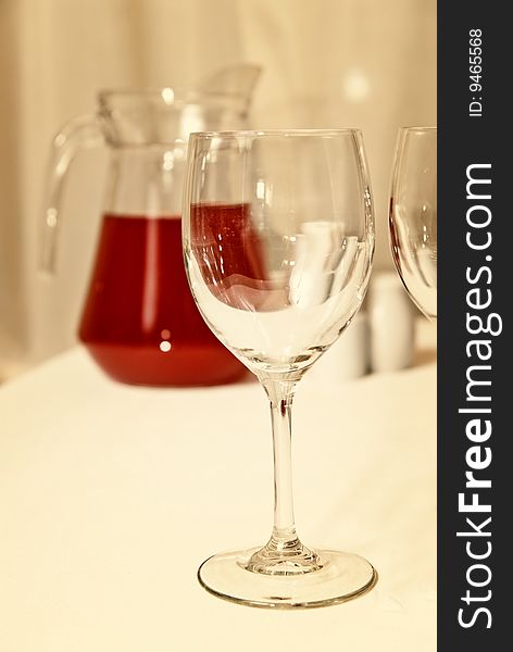 Glass goblet and red beverage on the table