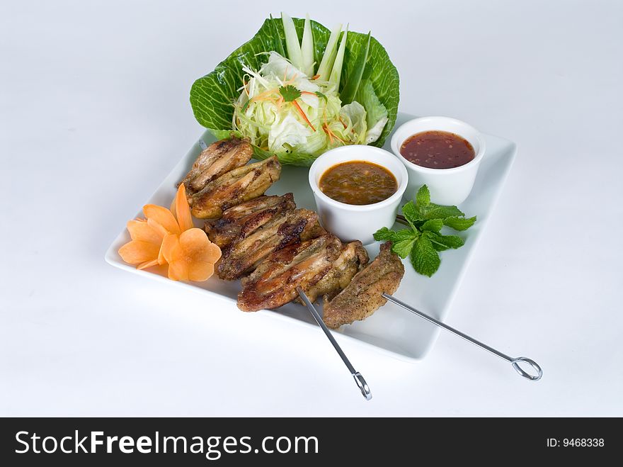 Chicken wing skewers with a salad and dipping sauce