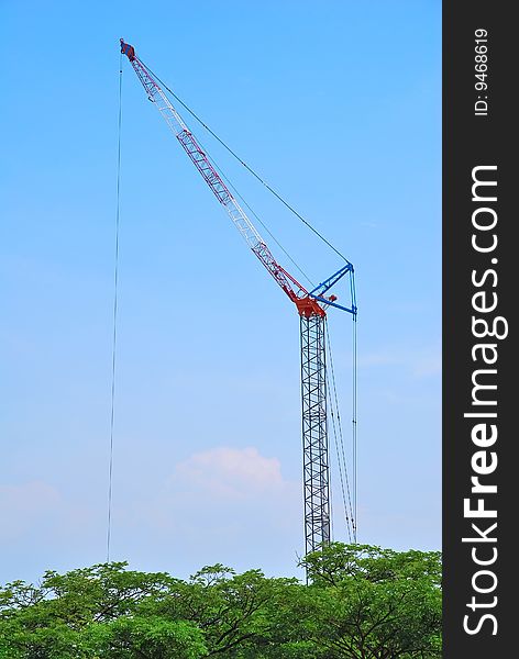 Huge, isolated construction crane towering above the trees. Huge, isolated construction crane towering above the trees